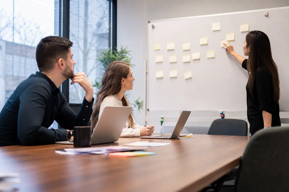 In-house HR team planning recruiting seats around a meeting table with laptops